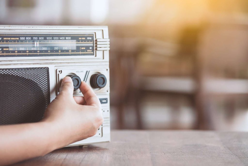 Vintage Radio an dessen Lautstärkeknopf gedreht wird
