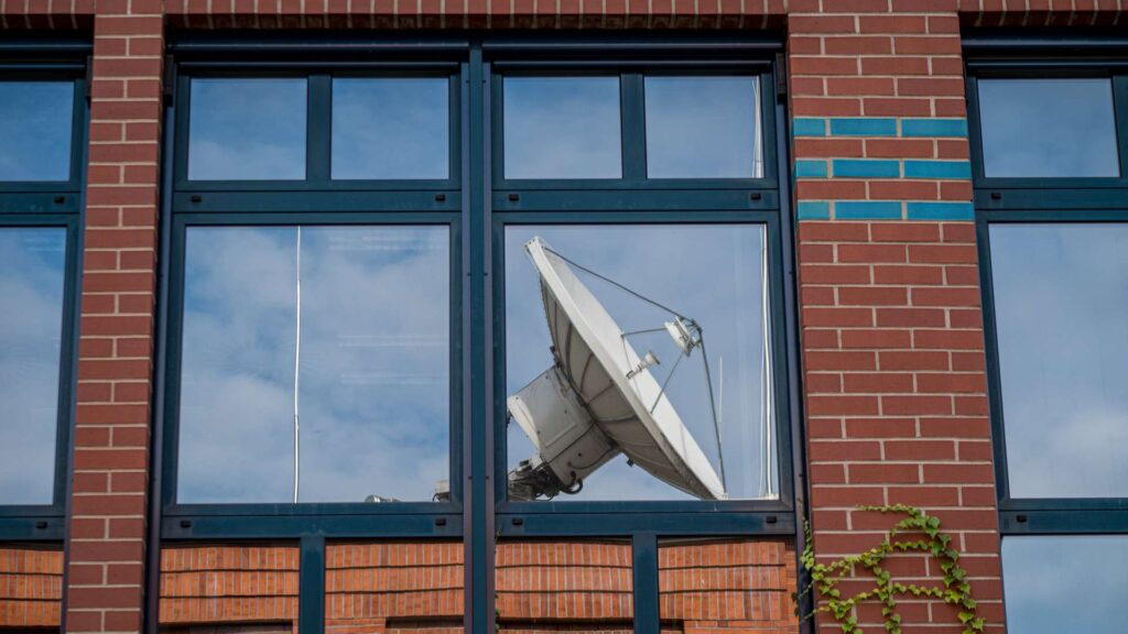 Spiegelung einer Satelliten Schüssel in einem Fenster
